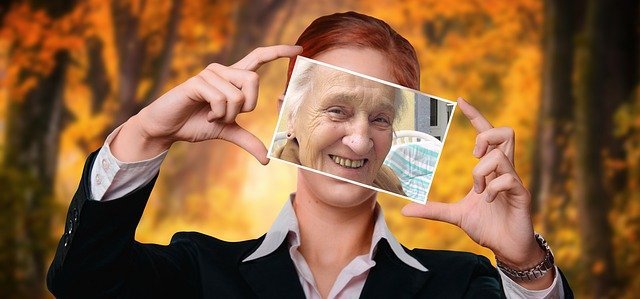 Photo of a smiling older woman' face held up in front of a smiling younger woman's face - embracing youthful attitude even as we age